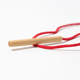 Grimms wooden threading needle showing needle detail with red cord attached