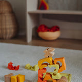 The yellow an natural wooden blocks from the Grimm's yellow building set stacked up on top of each other on the yellow tray. These Grimm's toys are part of a wide range of wooden toys available here at Babipur. 
