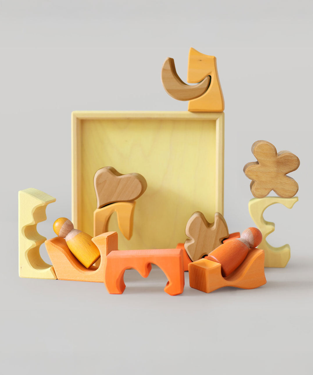 The yellow and natural wooden blocks from the Grimm's yellow building set used in a small world play scene with the Grimm's friends wooden peg dolls. These Grimm's toys are part of a wide range of wooden toys available here at Babipur. 