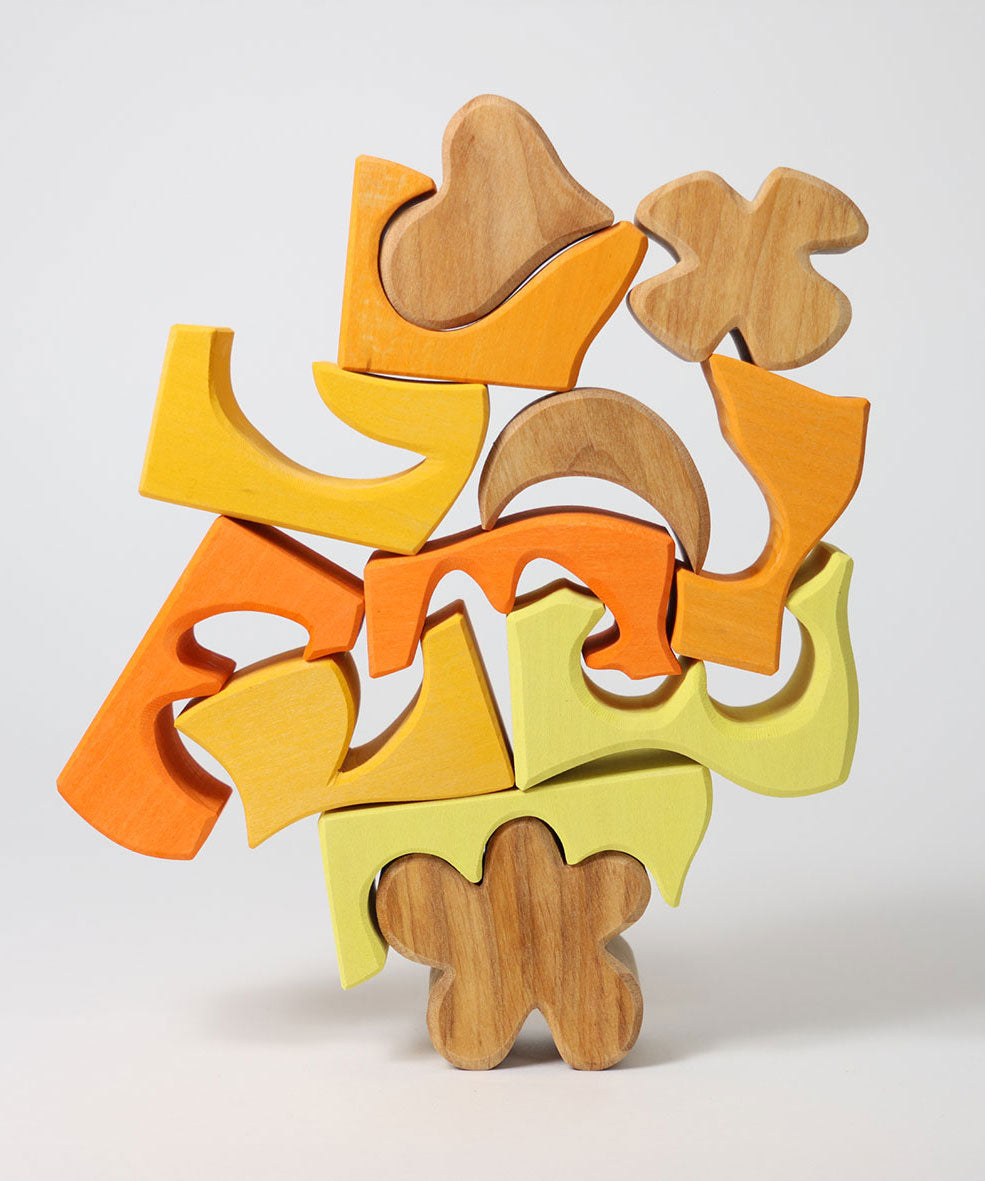 The yellow an natural wooden blocks from the Grimm's yellow building set stacked up on top of each other. These Grimm's toys are part of a wide range of wooden toys available here at Babipur. 