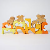 The yellow an natural wooden blocks from the Grimm's yellow building set stacked up on top of each other. These Grimm's toys are part of a wide range of wooden toys available here at Babipur. 