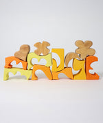 The yellow an natural wooden blocks from the Grimm's yellow building set stacked up on top of each other. These Grimm's toys are part of a wide range of wooden toys available here at Babipur. 