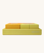 A side profile view of the yellow tray . Grimm's Building Set in Yellow. Wooden blocks in variopus shades of yellow and natural wood in a yellow coloured wooden storage tray. These Grimm's toys are part of a wide range of wooden toys available here at Babipur. 