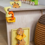 A child playing with the Grimm's Building Set in Yellow placing them on a table. Wooden blocks in various shades of yellow and natural wood in a yellow coloured wooden storage tray. These Grimm's toys are part of a wide range of wooden toys available here at Babipur. 