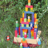 Grimm's small stepped counting blocks stacked up outdoors with Grimm's friends peg dolls placed on the stack