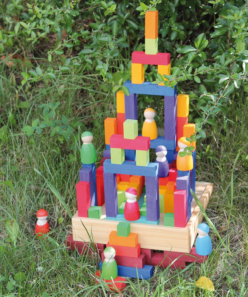 Grimm's small stepped counting blocks stacked up outdoors with Grimm's friends peg dolls placed on the stack