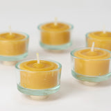 A closeup of the Grimm's beeswax tealights in the glass tealight holders.