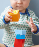 A close up of the orange wooden cube from the Haba blocks with sounds set.