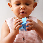 A child playing with the blue cube from the Haba blocks with sounds set