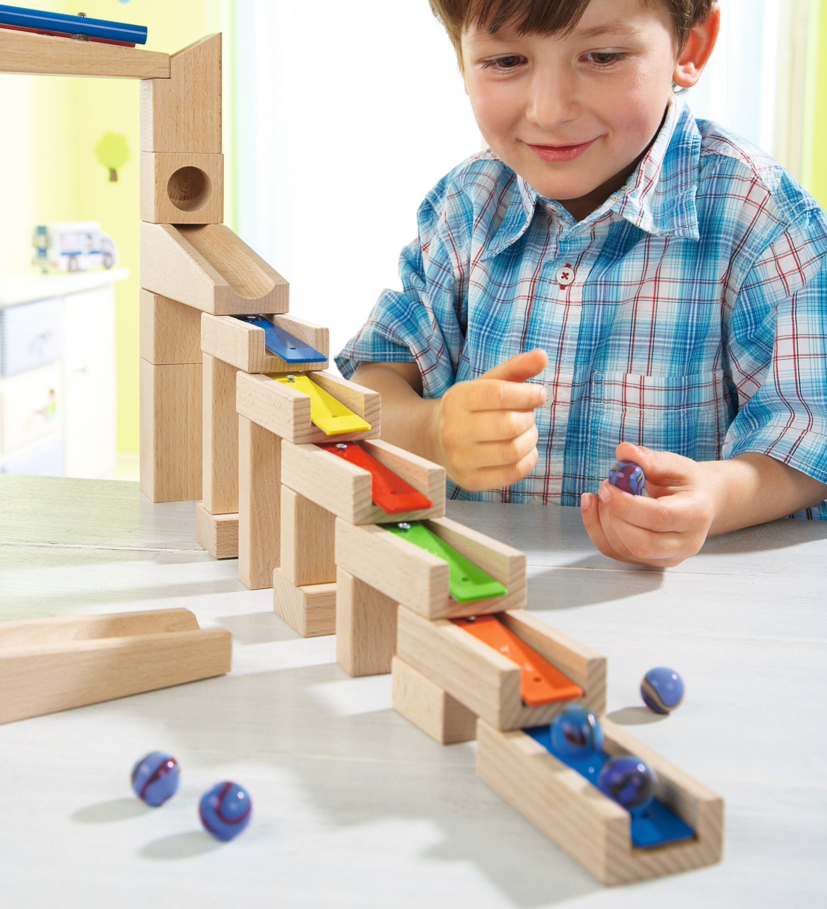 A child happily making music with the HABA Wooden Melodious Marble Run