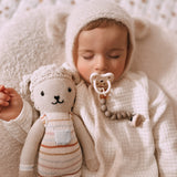 Close up of baby sleeping next to a cuddly toy with a dummy in his mouth