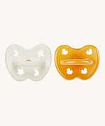 A two-pack of Hevea symmetrical teat baby pacifiers, made from 100% natural rubber and plastic-free. One in a milky white colour and one in a natural orange