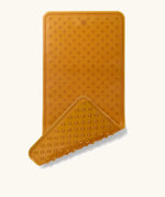 Hevea large natural rubber bath mat with corner flipped showing suction cups on the bottom, and a wave pattern on top for non-slip.