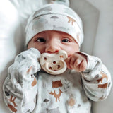 A closeup of a baby with the Hevea natural rubber pacifier dummy with a symmetrical nipple shape, in milky white 