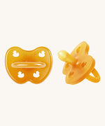 A two-pack of Hevea symmetrical teat baby pacifiers, made from 100% natural rubber and plastic-free. Both in a natural orange