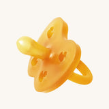 The Hevea natural rubber pacifier dummy with a symmetrical nipple shape, in a natural orange colour