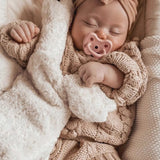 A baby sleeping with a Senger stuffed toy, with a Hevea natural rubber pacifier in pink