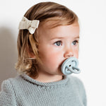 Close up of young child with a Hevea natural rubber pacifier in her mouth