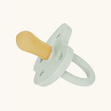The Hevea natural rubber pacifier dummy in soft pebble green with a symmetrical nipple shape.