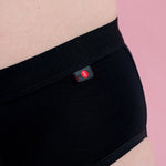 Hey Girls Basic Brief - Black Period Pants label details against a pink background