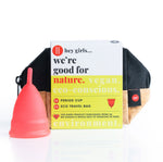 Hey Girls menstrual silicone cup in large in red next to it's travel bag on a white background
