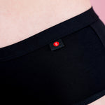 Hey Girls Mid Waist Black Reusable Period Pants worn by a person against a pink background