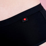 Hey Girls Mid Waist Black Reusable Period Pants worn by a person against a pink background