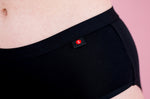 Hey Girls Mid Waist Black Reusable Period Pants worn by a person against a pink background