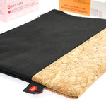 Close up of the Hey Girls reusable black cork dry bag laid out on a white background