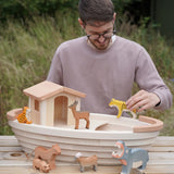 Adult holding a tiger figure on top of a Holztiger handcrafted wooden Noah's ark with other animals 