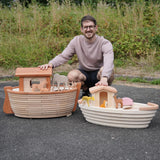 Adult kneeling behind the Holztiger handcrafted XL Noah's ark and the standard ark showing scale 