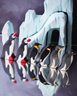 Bumbu and Ostheimer penguin figures lined up with a dark coloured background behind