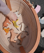 Holztiger wooden XL Noah's ark showing the removable lid off and a adult hand picking up a tiger figure inside