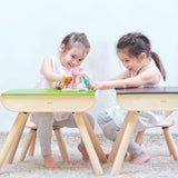 Two children sitting on PlanToys wooden chairs in front of PlanToys wooden desks.