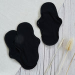 Imse Active Regular Period Pads in back placed on a wooden surface