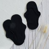 Imse Active Regular Period Pads in back placed on a wooden surface