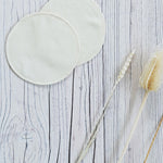 two Imse Vimse Merino Wool Breast Warmer Pads placed on a white coloured wooden background 