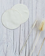 two Imse Vimse Merino Wool Breast Warmer Pads placed on a white coloured wooden background 