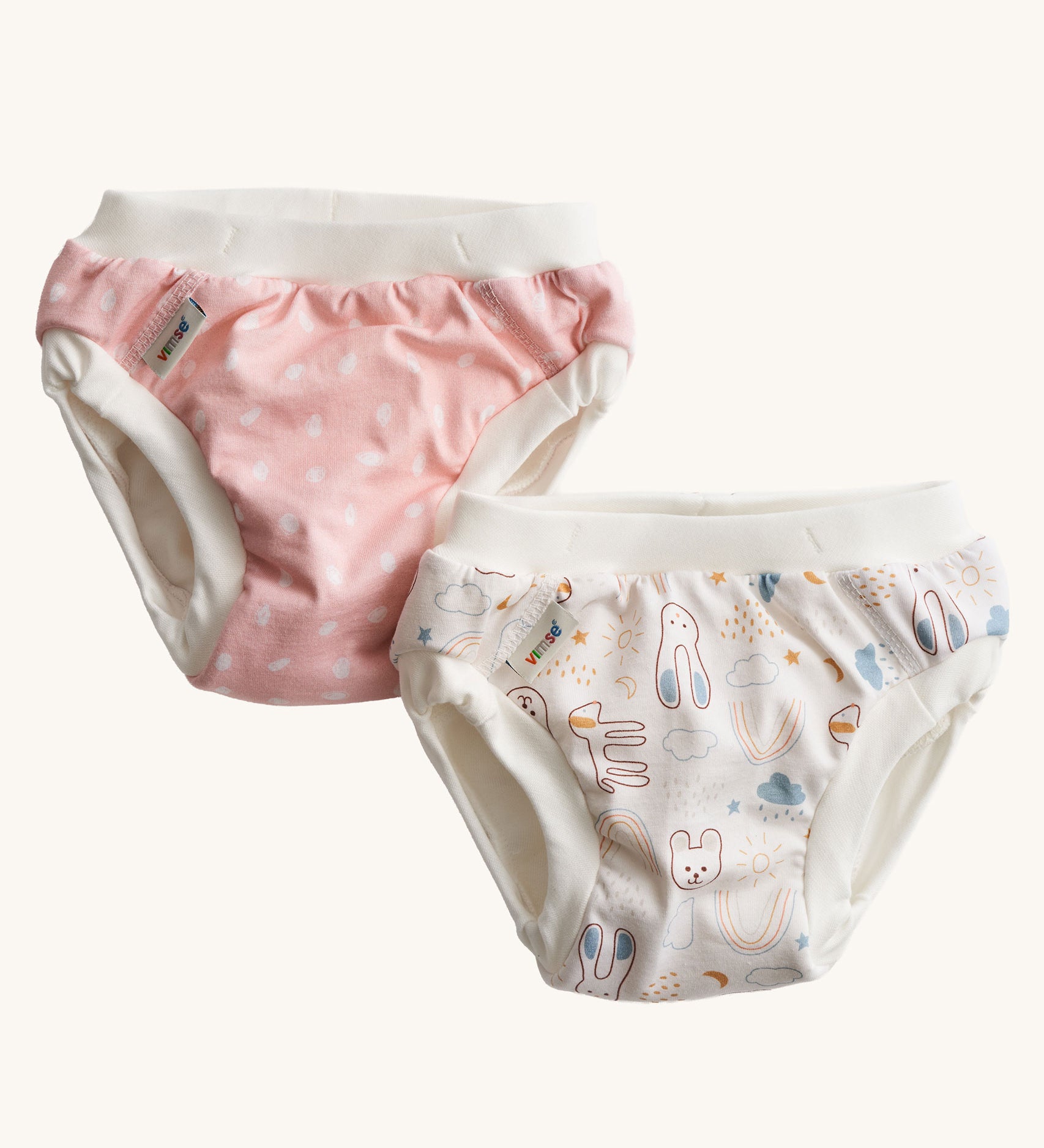 A pack of two Imse Vimse Pink and Teddy design reusable Training Pants for toddlers weighing from 16-20 kg available at Babipur. Two comfortable Cotton reusable training pants. The one on the left is pink with white scribbled sports, and the one on the right is white with colourful rabbits, bears, dogs, rainbows, clouds.