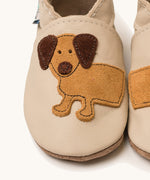A close up of the Inch Blue cream dash shoes available at Babipur showing the brown suede cut out dachshund design