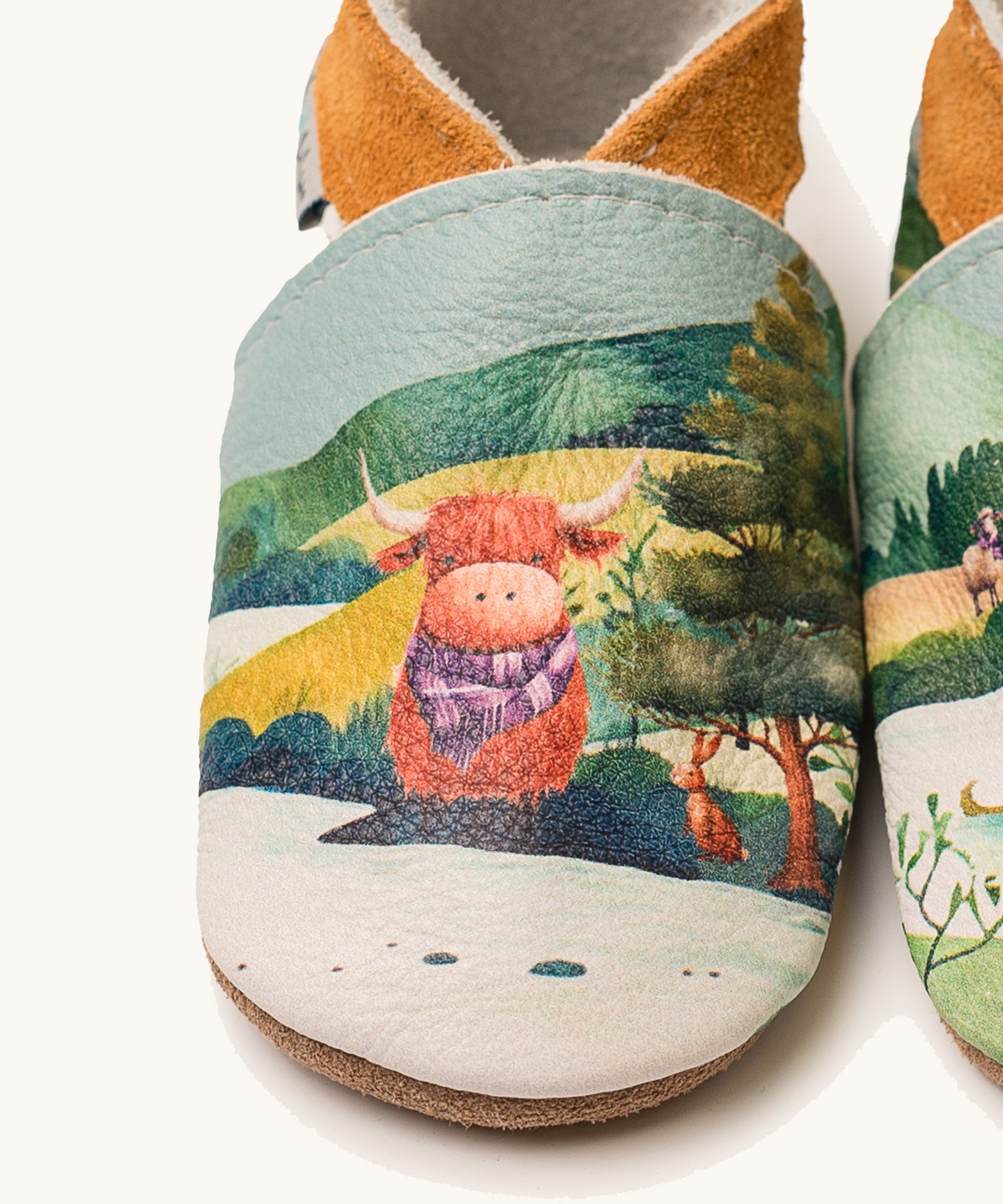 A close up of the Inch Blue highland cow shoes available at Babipur showing  a closer look at the highland cow design