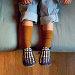 Child wearing Inch Blue Leather Baby Shoes - Bones with tan socks and jeans