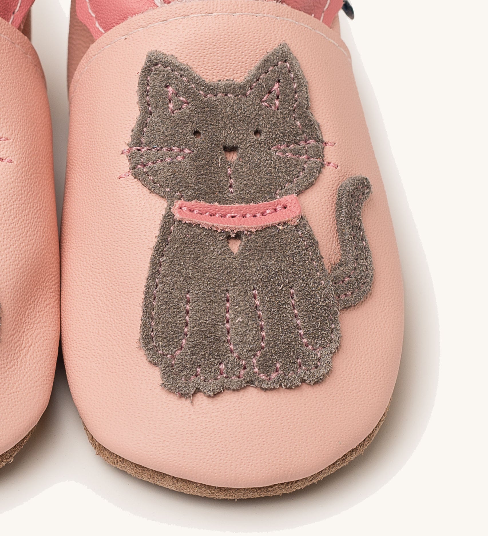 A close up of the Inch Blue meeow soft pink  baby shoes available at Babipur. Showing the grey suede cat cut out design