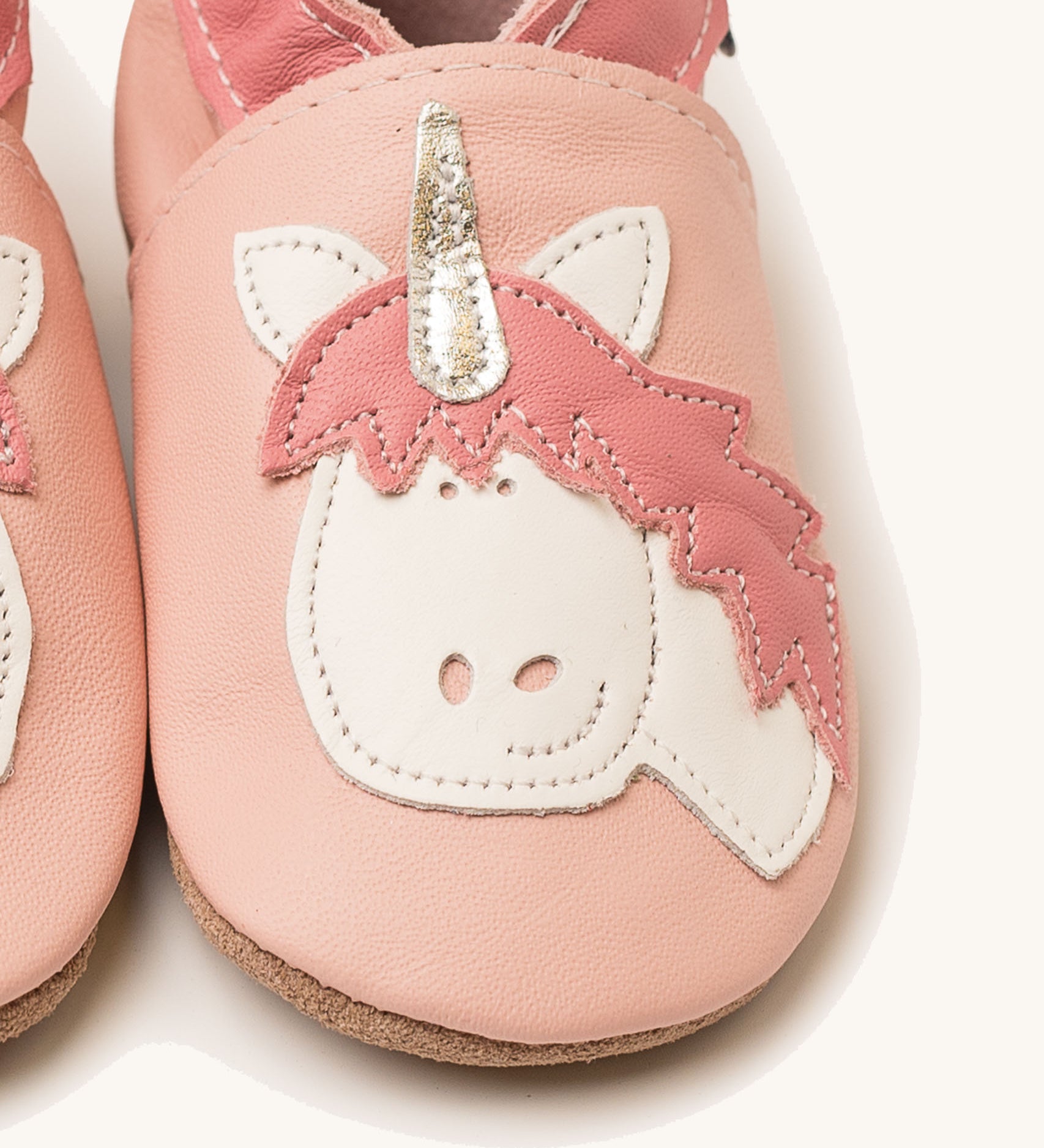 A close up of the Inch Blue pink unicorn baby shoes available at Babipur showing the white and pink unicorn cutout design