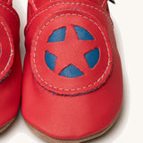 A close up of the Inch Blue superkid red baby shoes available at Babipur. Showing the red and blue star shield design