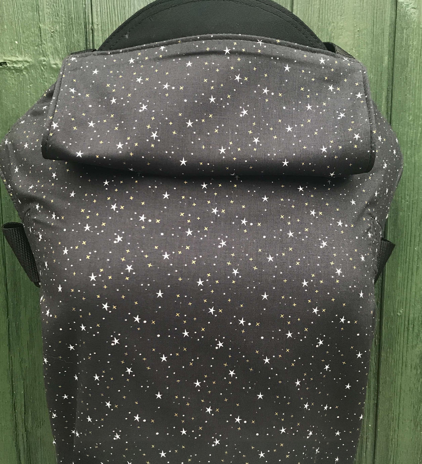 Integra believe design baby carrier available at a Babipur.  A grey carrier with a all over star design. Features a small hood for head protection.