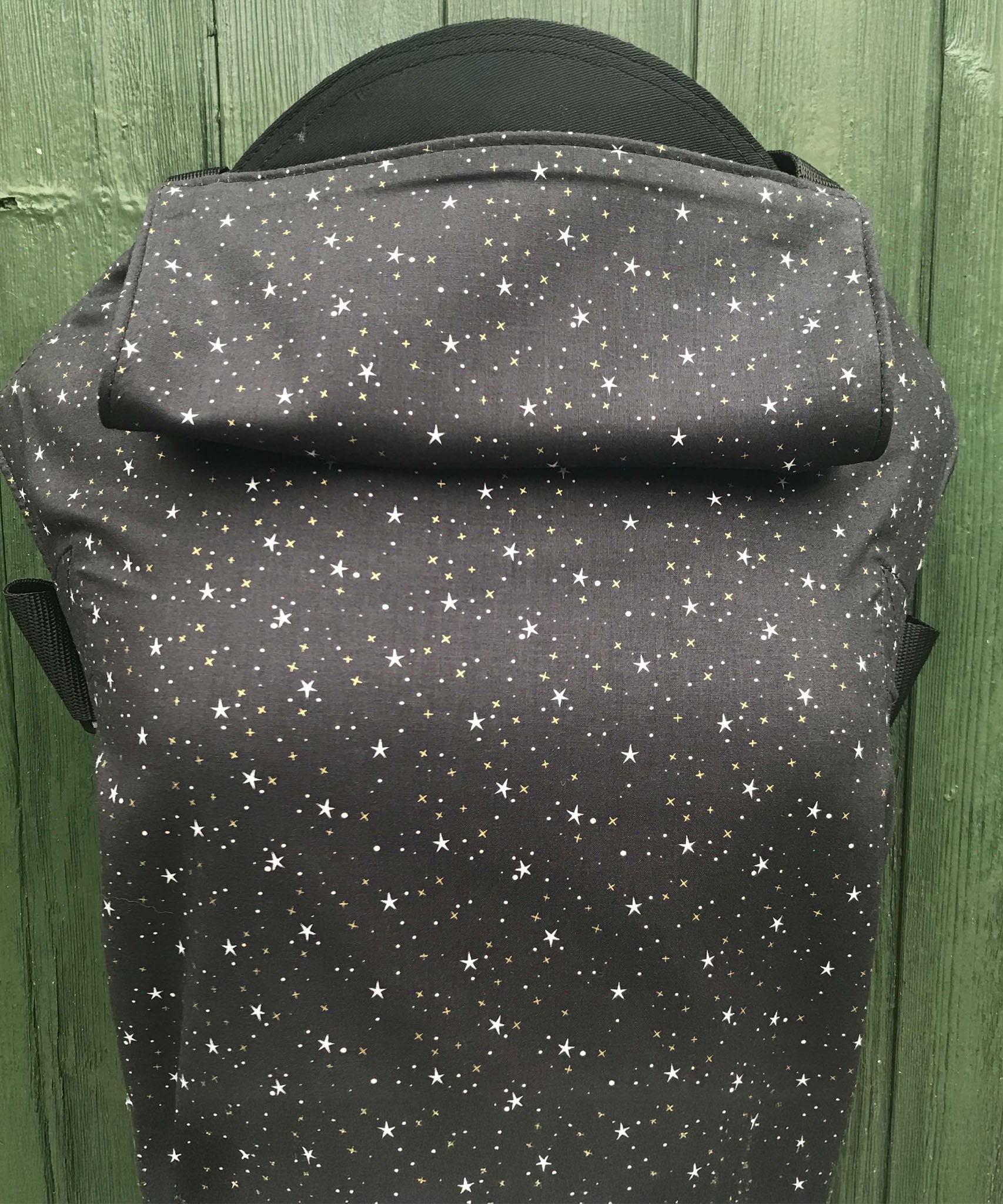 Integra believe design baby carrier available at a Babipur.  A grey carrier with a all over star design. Features a small hood for head protection.