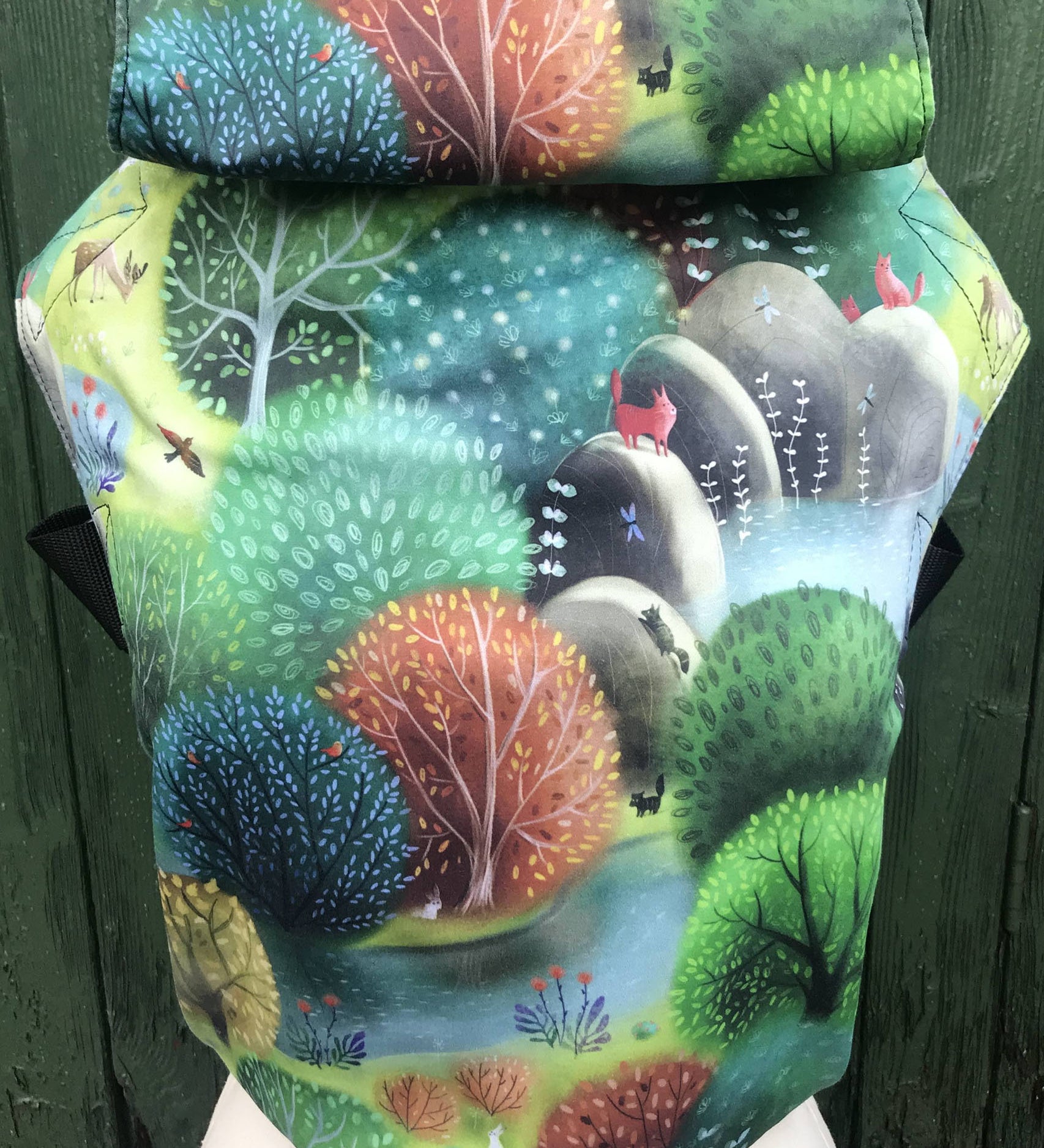 Integra forest glade baby carrier available at a Babipur a sketch style design of a forest with various animals. Features a small hood for head protection.