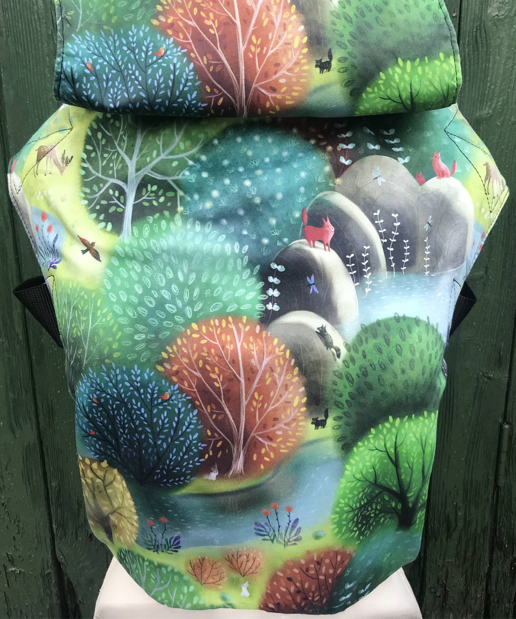 Integra forest glade baby carrier available at a Babipur a sketch style design of a forest with various animals. Features a small hood for head protection.