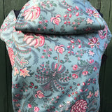 Integra Martha baby carrier available at a Babipur a light blue coloured carrier with a vintage pink floral design. Features a small hood for head protection.